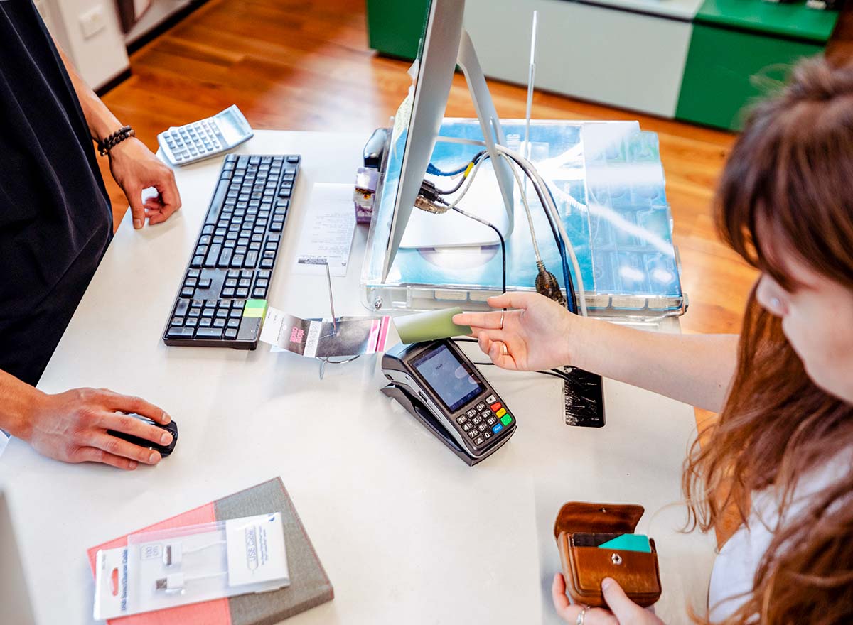 Overhead shot of person purchasing supplies with cashier in college bookstore